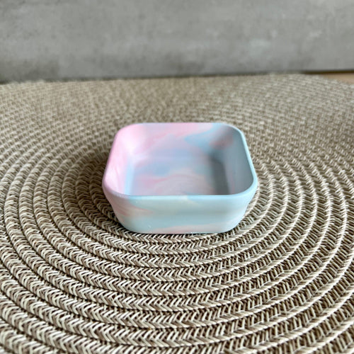 Eine viereckige Schmuckchale in blau-rosa Marmorierung